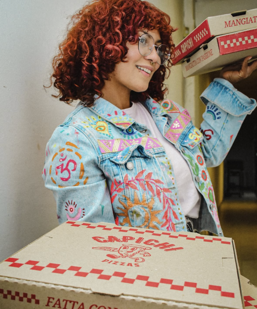 Clienta recibiendo su pizza Capichi